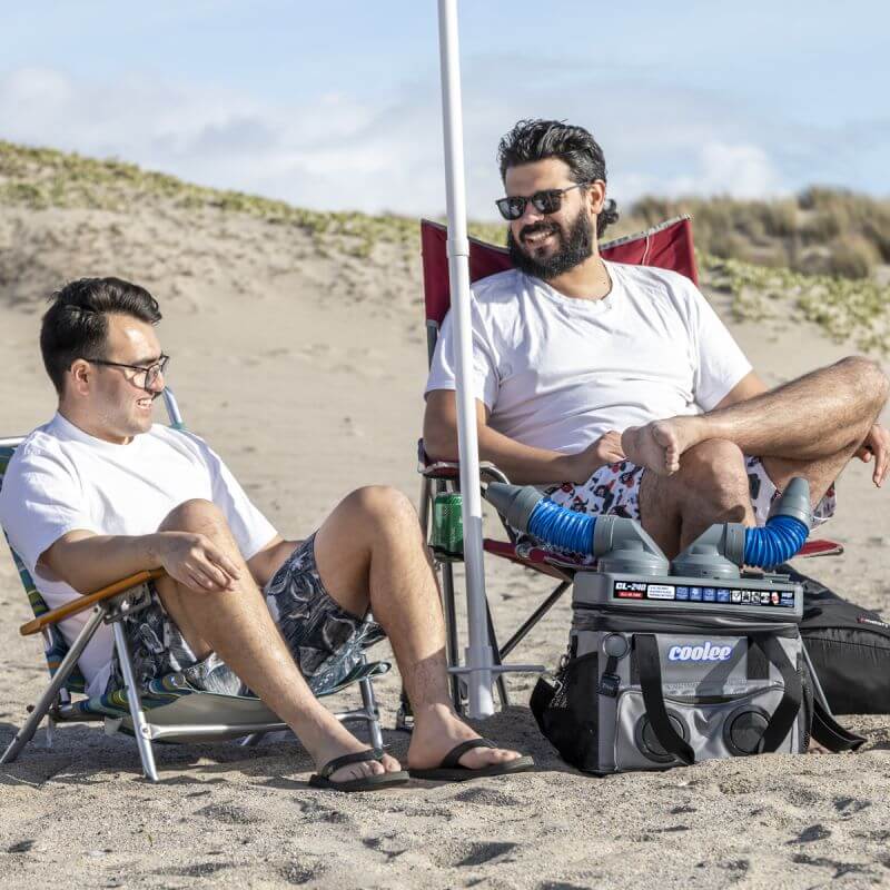 Two men relax on the beach with the Cool Boss Coolee CL-240, enjoying a cool breeze and refreshments.