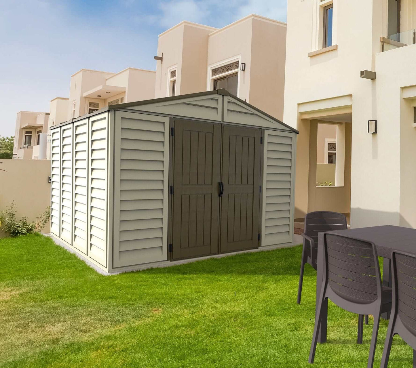 Duramax 10.5x10 Woodbridge Plus Vinyl Shed in backyard setting with lawn and patio furniture.