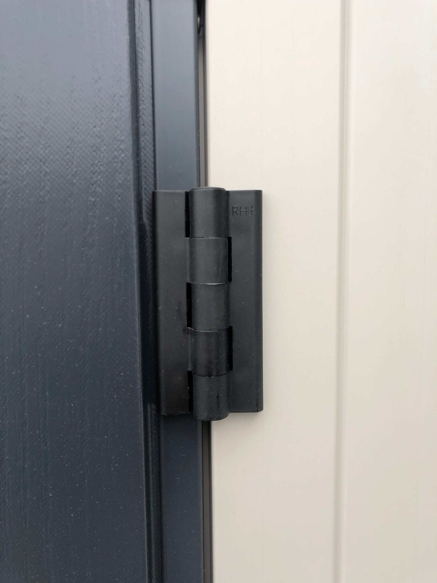 Close-up of a durable black hinge on the Duramax Vinyl Shed for secure door operation.