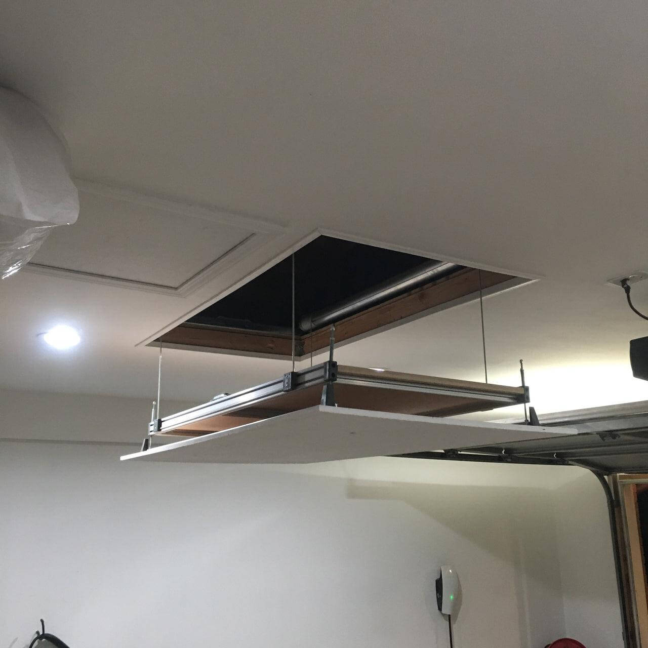 Auxx Attic Lift installed in garage ceiling, providing easy access for efficient storage solutions.