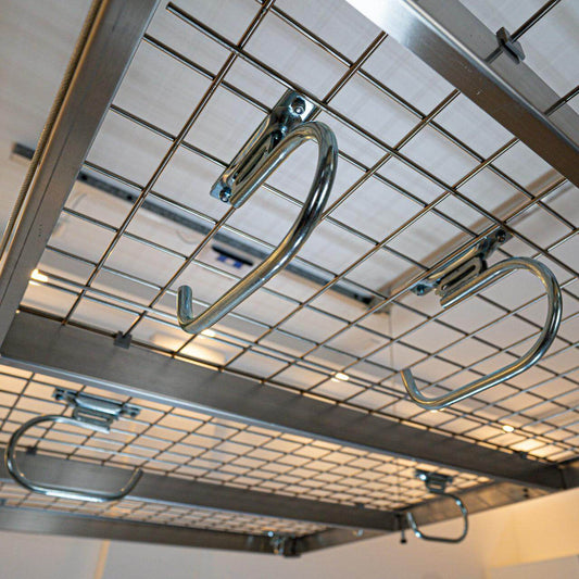 Auxx Lift hooks on a metal grid, designed to attach various accessories like kayaks and cargo carriers. 