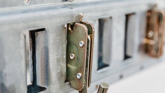 Close-up of Auxx Lift J-hook snap-in anchor attached to track, designed for heavy-duty load securing and equipment hanging. 
