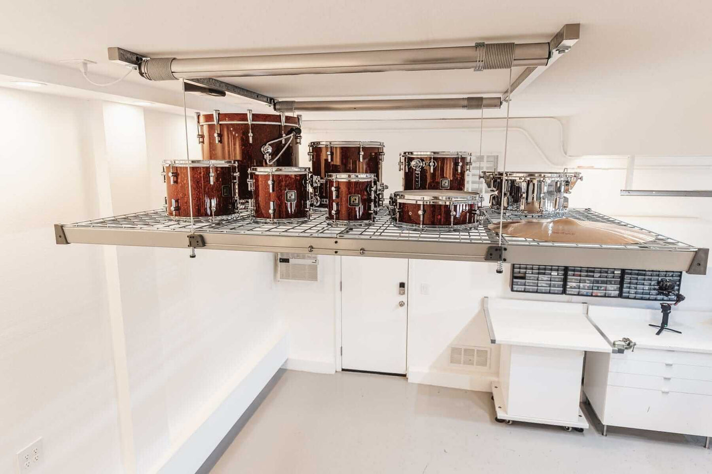 Auxx Lift elevating a platform with drum set for efficient garage storage solutions.