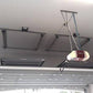 Motorized garage storage lift system in the ceiling, showcasing the Auxx Lift for efficient overhead storage.