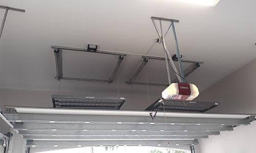 Motorized garage storage lift system in the ceiling, showcasing the Auxx Lift for efficient overhead storage.