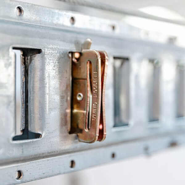 Close-up of Auxx-One universal lift's metal rail with safety clip for secure motorized garage storage.