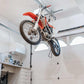 Motorcycle hoisted above garage floor using Auxx-One motorized garage storage lift.