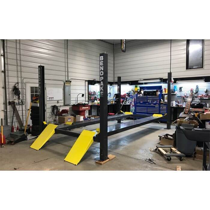 BendPak HD-7P 4 Post Car Lift installation in a garage, showcasing space-saving parking solution.