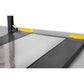 Close-up view of the BendPak HD-9XW four-post car lift platform with textured metal surface and safety yellow edges.