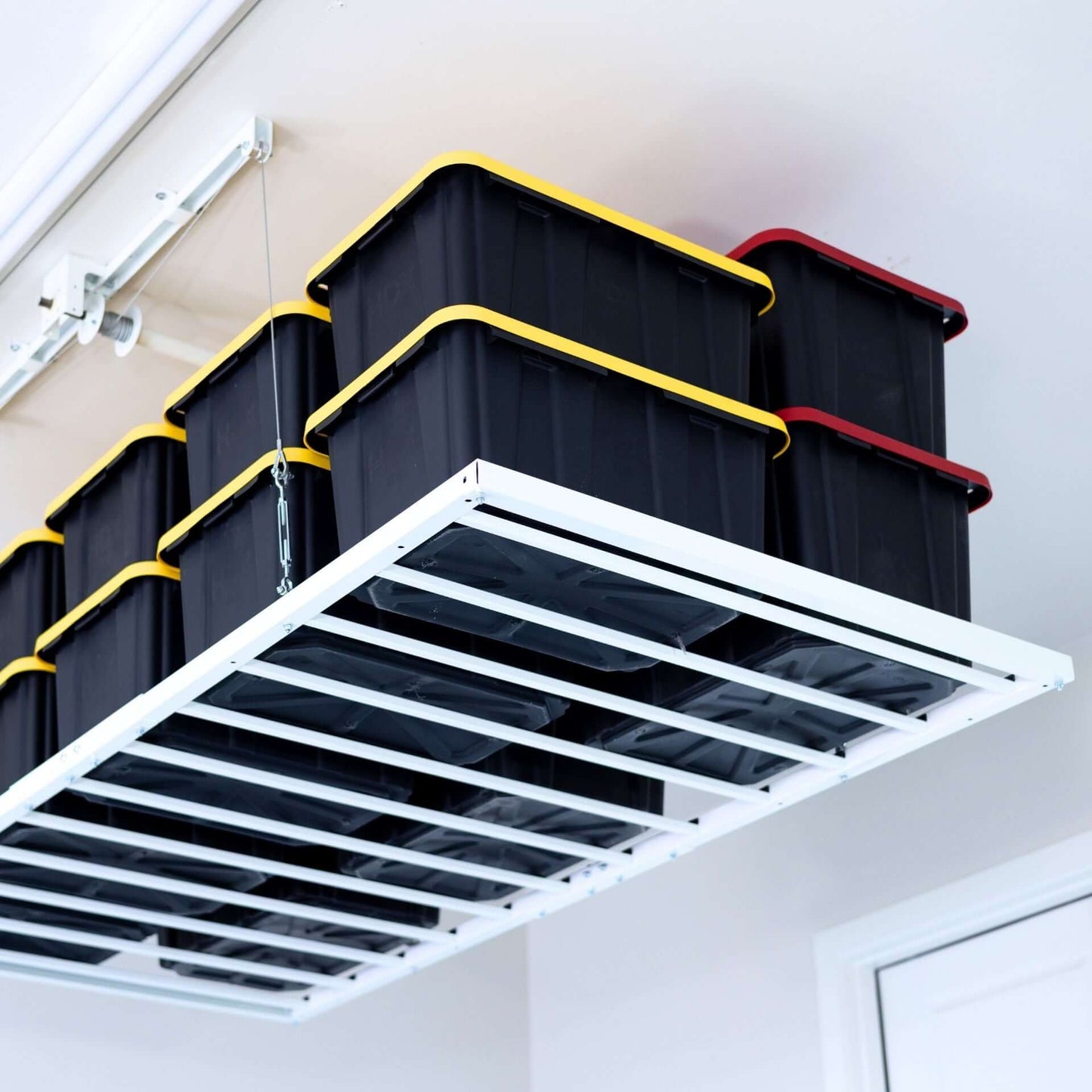 Ceiling Sam Retractable 4x8 Garage Ceiling Storage Lift showcasing stacked totes in a spacious garage.