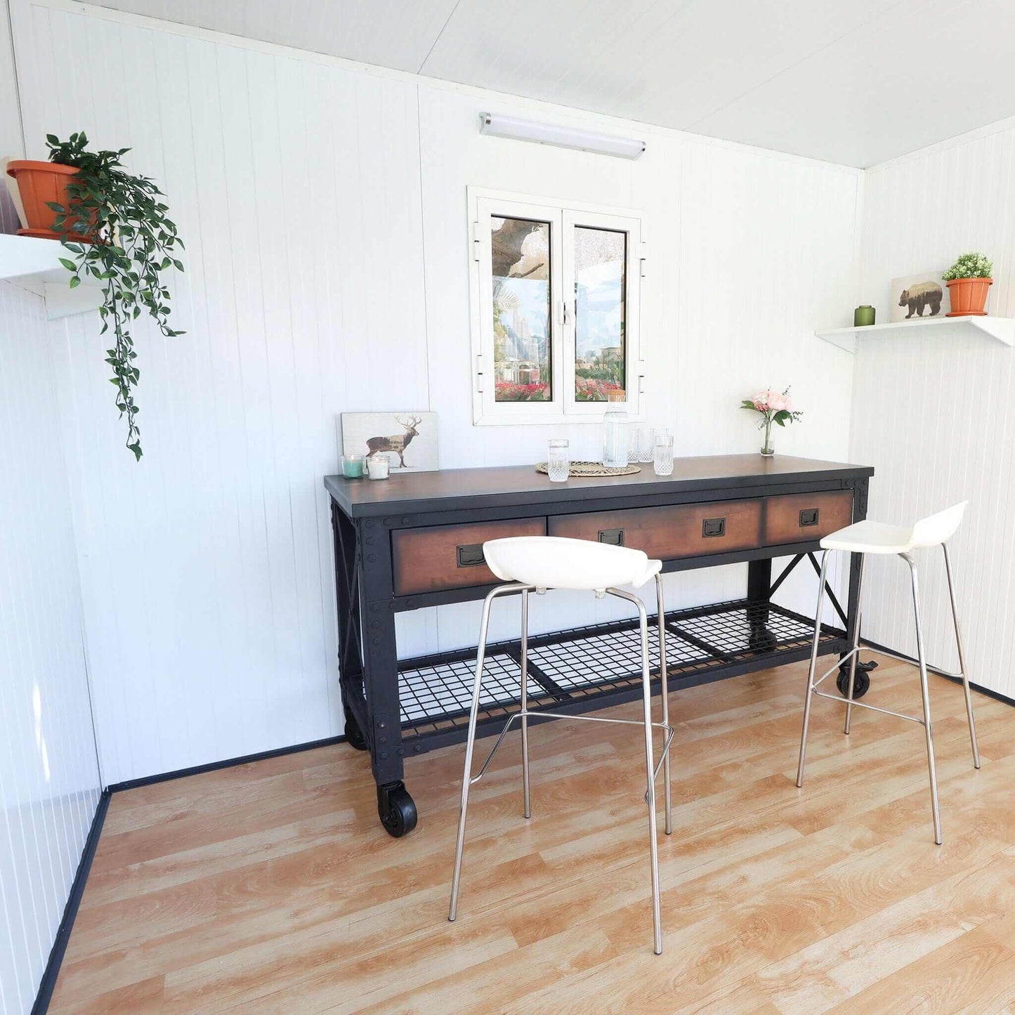 Interior view of a Duramax 10x10 glass garden room featuring a modern table and chairs with natural decor.