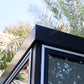 Close-up of Duramax 10x10 Glass Garden Room roof detail with palm leaves in the background.