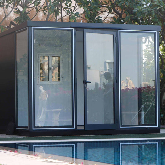 Duramax 10x10 insulated glass garden room beside a pool, featuring sleek design and large windows. 
