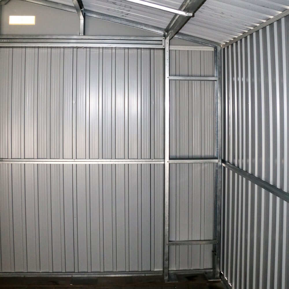 Interior view of a Duramax metal garage showcasing the sturdy gray walls and shelving support structure.