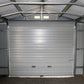 Interior view of the Duramax 12x20 Imperial Metal Garage with gray walls and a large roll-up door.