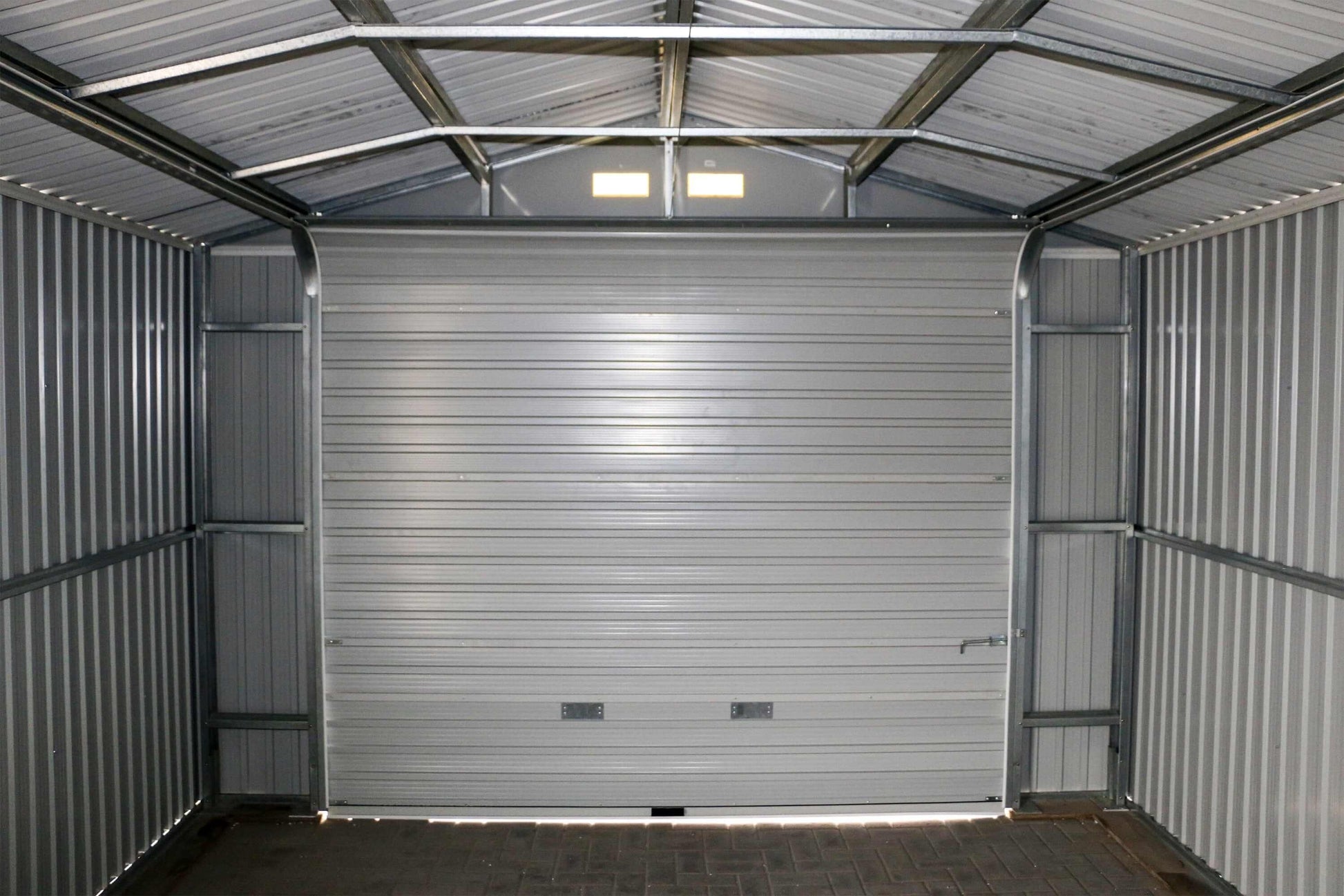 Interior view of the Duramax 12x20 Imperial Metal Garage with gray walls and a large roll-up door.