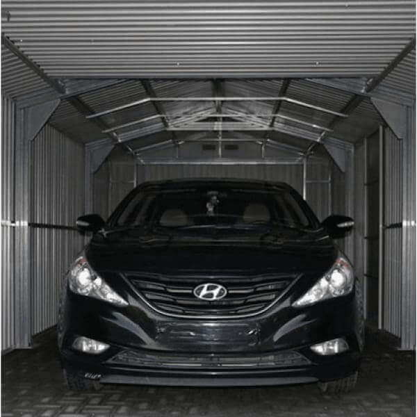 Black Hyundai parked inside a Duramax metal garage with silver interior walls and curved roof.