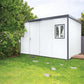 Duramax 13x10 flat roof insulated building in backyard, perfect for storage and work areas.