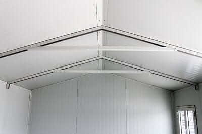 Interior view of a Duramax gable roof insulated building, showcasing the structural support and white paneling.