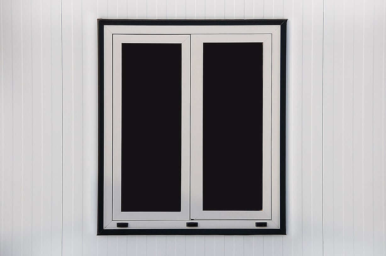 Double window with a sleek white frame against a light wooden wall.