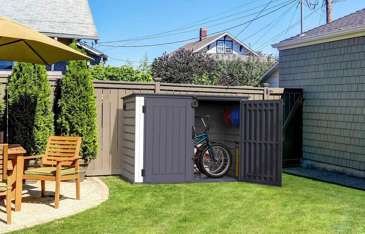 Duramax 2100L MultiStore outdoor storage shed in a backyard with bike and patio furniture.