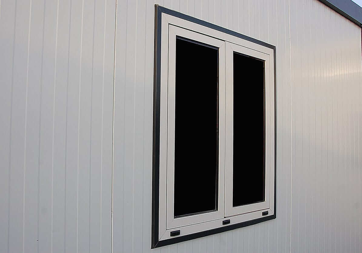 Close-up of a double-window installation on a flat-roof insulated building, showcasing modern design and durability.