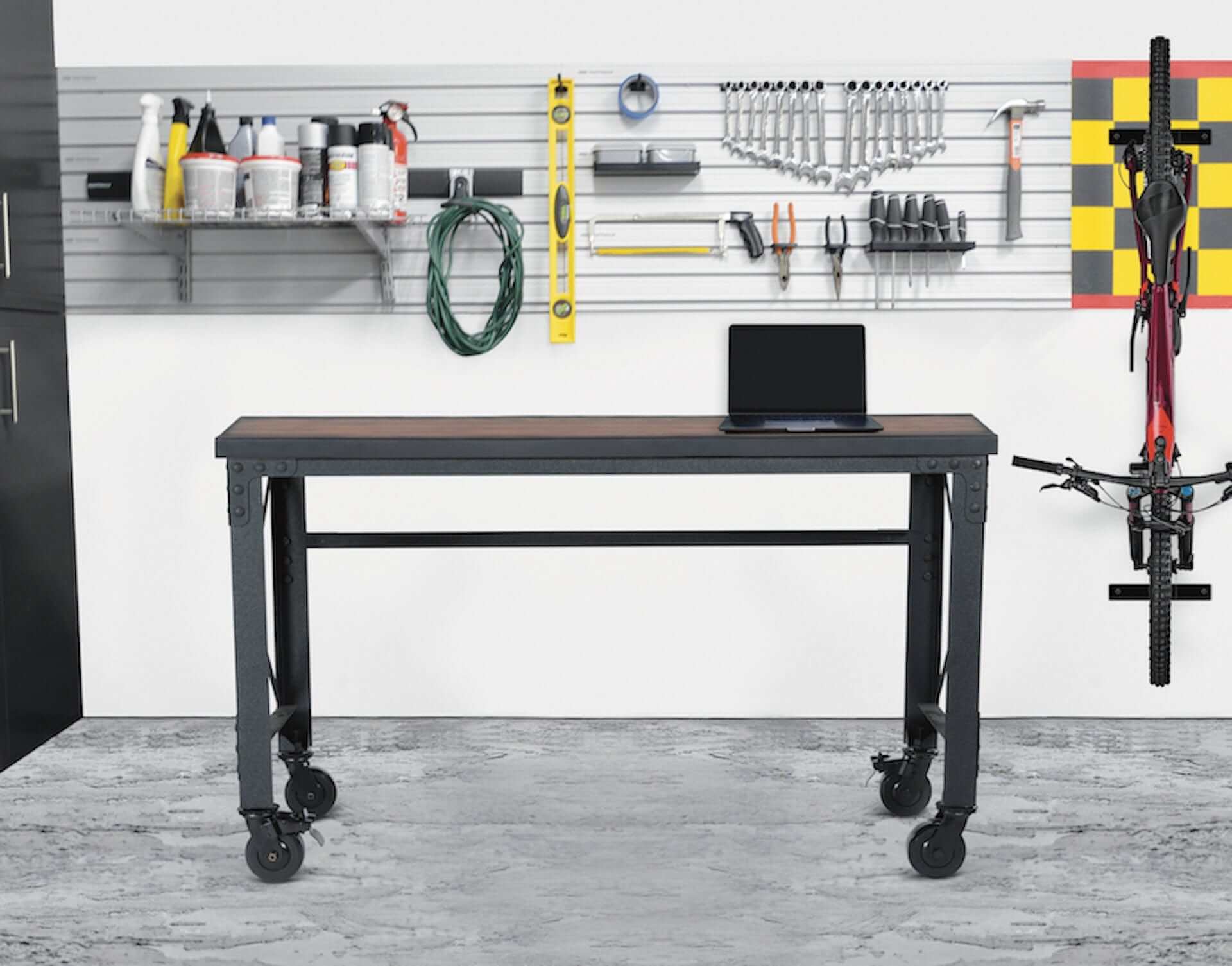 Duramax 62 In x 24 In Rolling Industrial Worktable in a garage with tools and a bike on the wall.