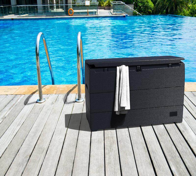 Duramax 71 Gallon Deck Box Gray by poolside with towels, perfect for outdoor storage and seating.