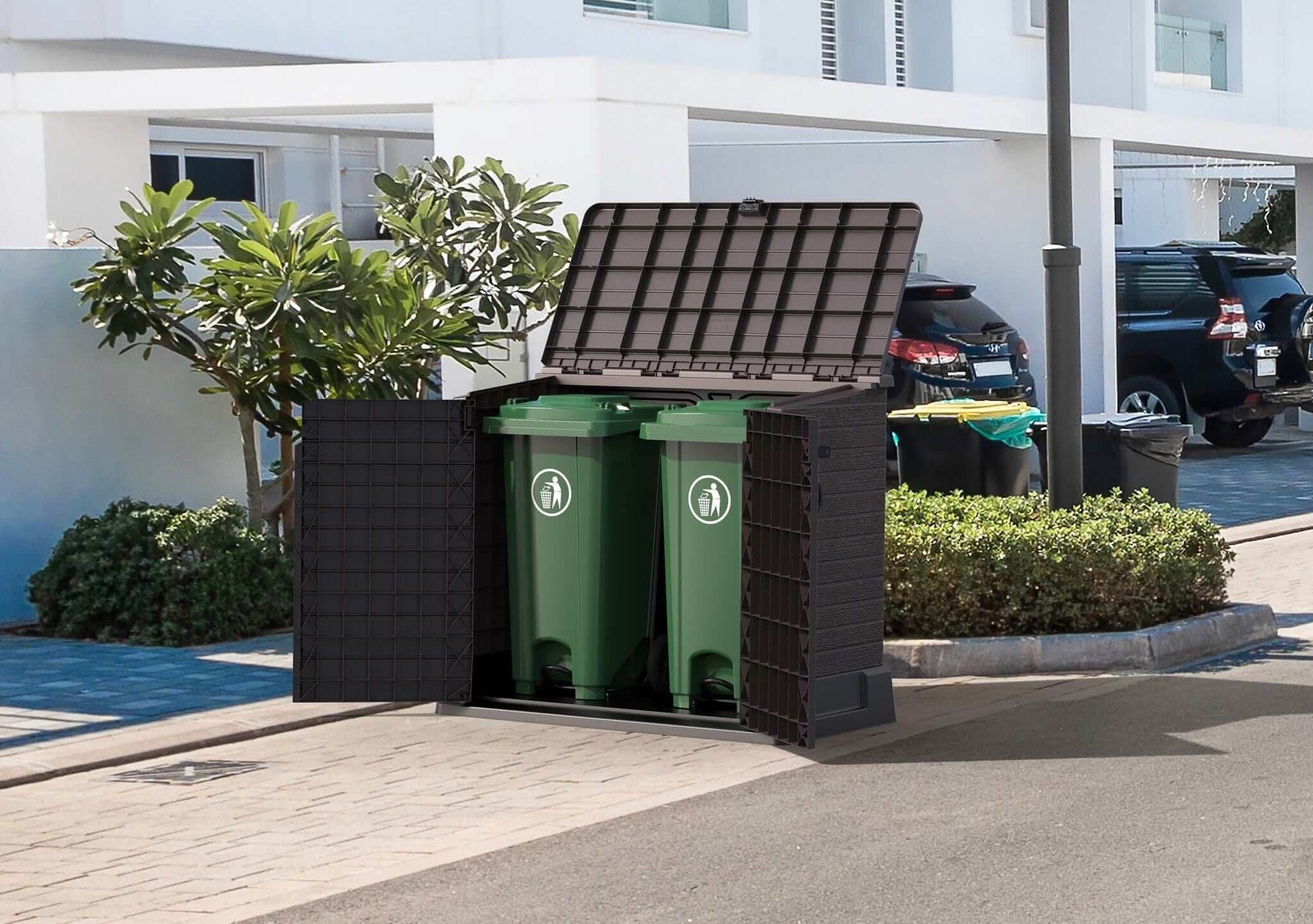 Duramax StoreAway 850L gray storage unit showcasing two green trash bins in a suburban setting.