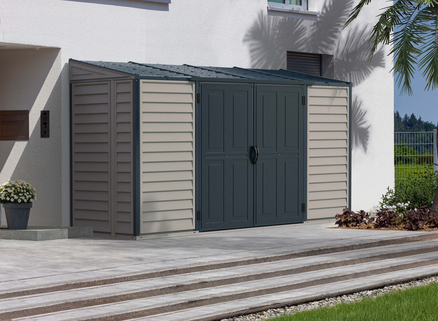 Duramax Vinyl Shed 10 x 4 SideMate Plus ProStorage 36825 placed beside a house, featuring a gray and beige design. 