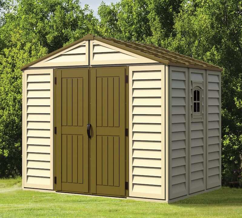 Duramax Vinyl Shed 10.5x8 Woodbridge Plus with foundation, featuring double doors and window in a garden setting.