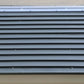 Top view of a dark gray corrugated shed roof with horizontal lines and fasteners.