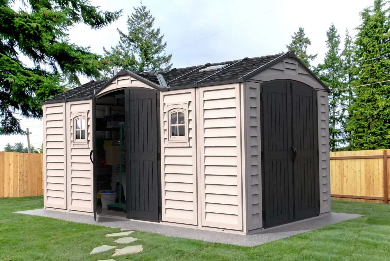 Duramax Vinyl Shed 15 x 8 Apex Pro with foundation in a landscaped yard, showcasing durable storage solution.