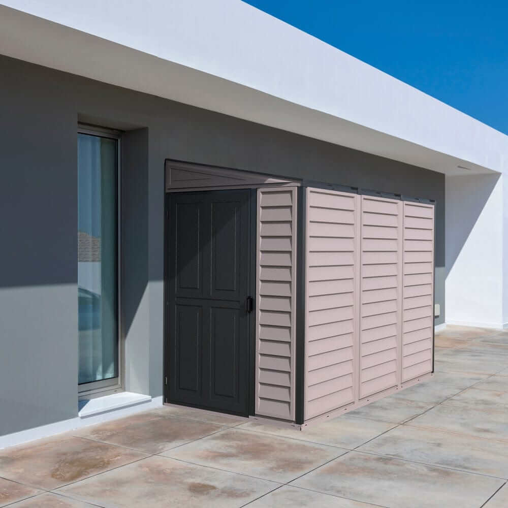 Duramax Vinyl Shed 4x8 SideMate Plus in gray, placed against a modern building exterior.