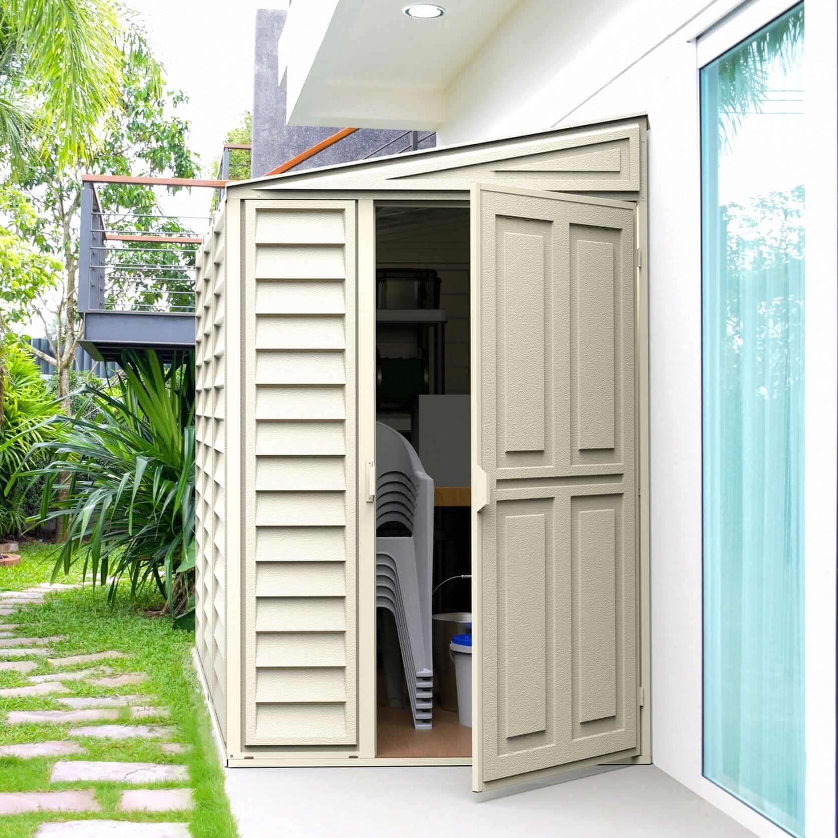 Duramax 4x8 SideMate vinyl shed with open doors, showcasing outdoor storage in a narrow yard space.