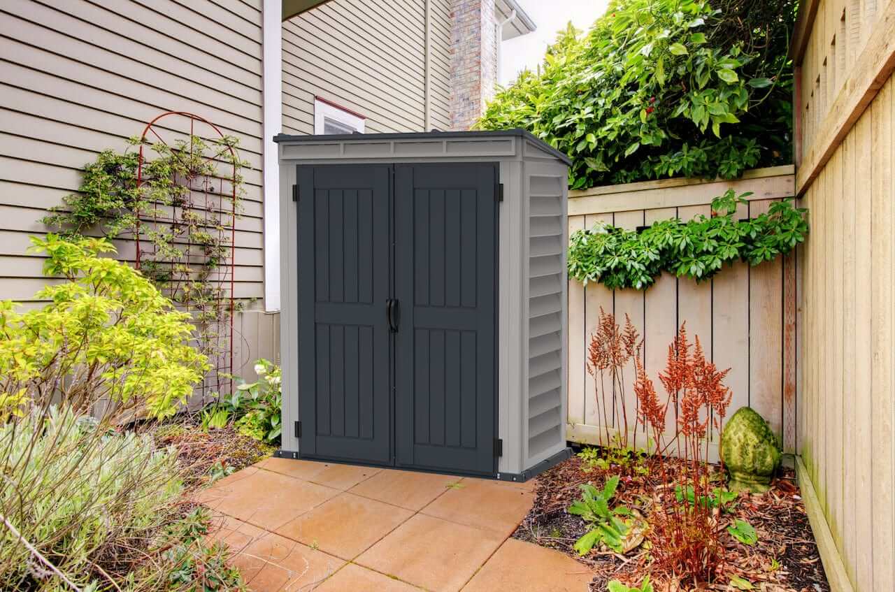 Duramax 5x3 YardMate Pent Roof vinyl shed with floor in a garden setting, showcasing outdoor storage solution.