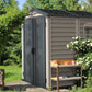 Duramax Vinyl Shed 6x6 StoreMate Plus in a garden setting surrounded by greenery and flowers.