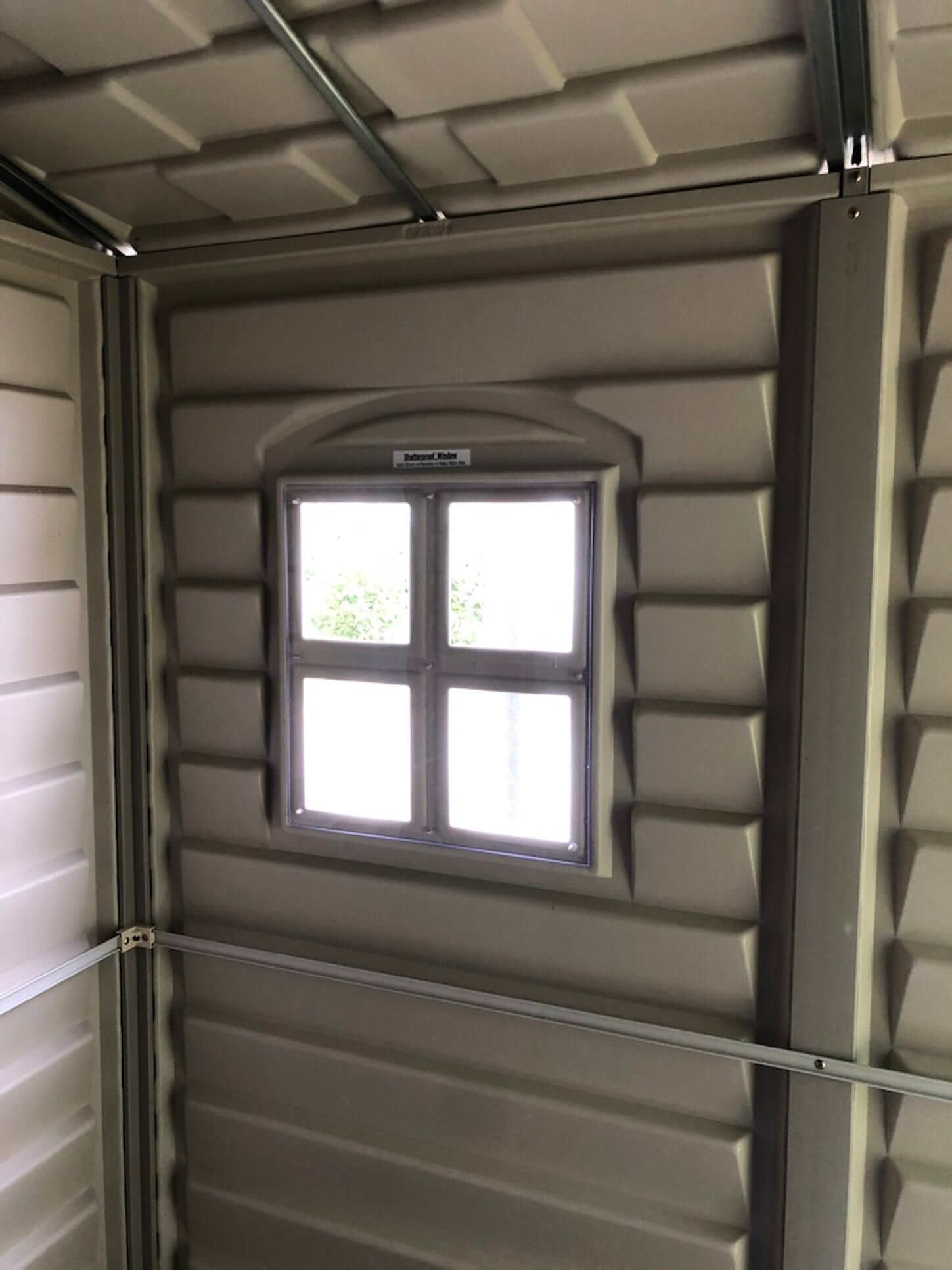 Interior view of Duramax Vinyl Shed showing a window for natural light and ventilation.