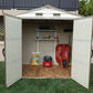 Duramax 8x6 Vinyl Shed interior with shelves, wheelbarrow, and garden tools, ideal for outdoor storage.