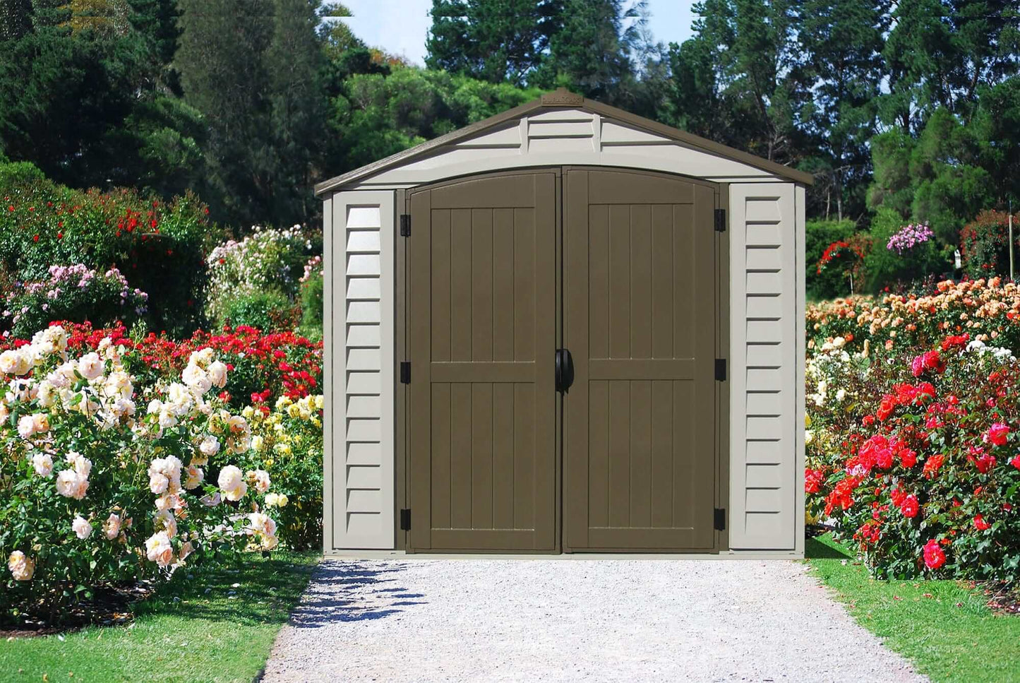 Duramax 8x8 DuraPlus vinyl shed in a colorful flower garden, featuring double doors and a classic design.