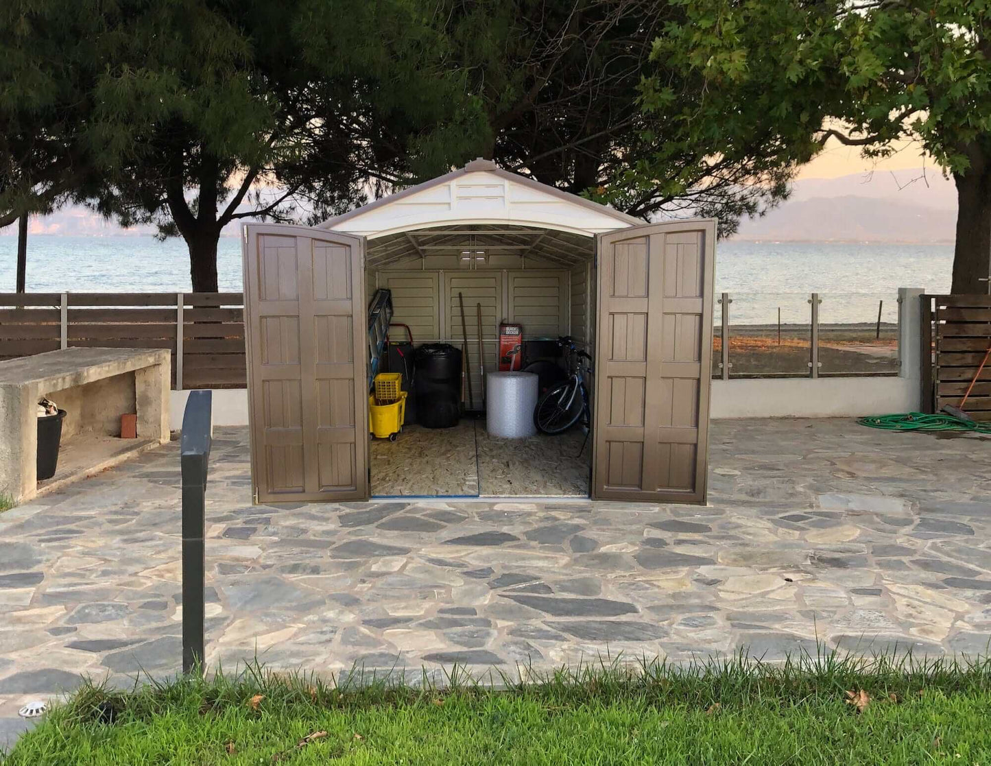 Duramax Vinyl Shed 8x8 DuraPlus with open doors, showcasing organized storage and scenic background.