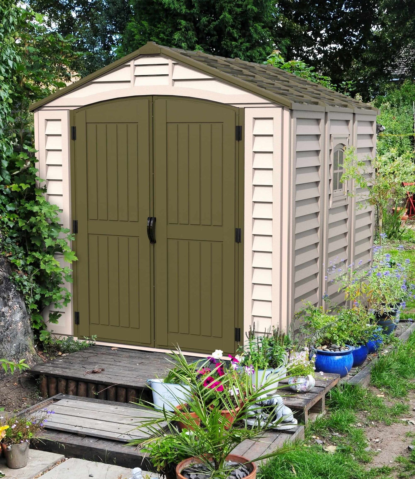 Duramax 8x8 DuraPlus vinyl shed with foundation in a garden setting, featuring a modern design and double doors.