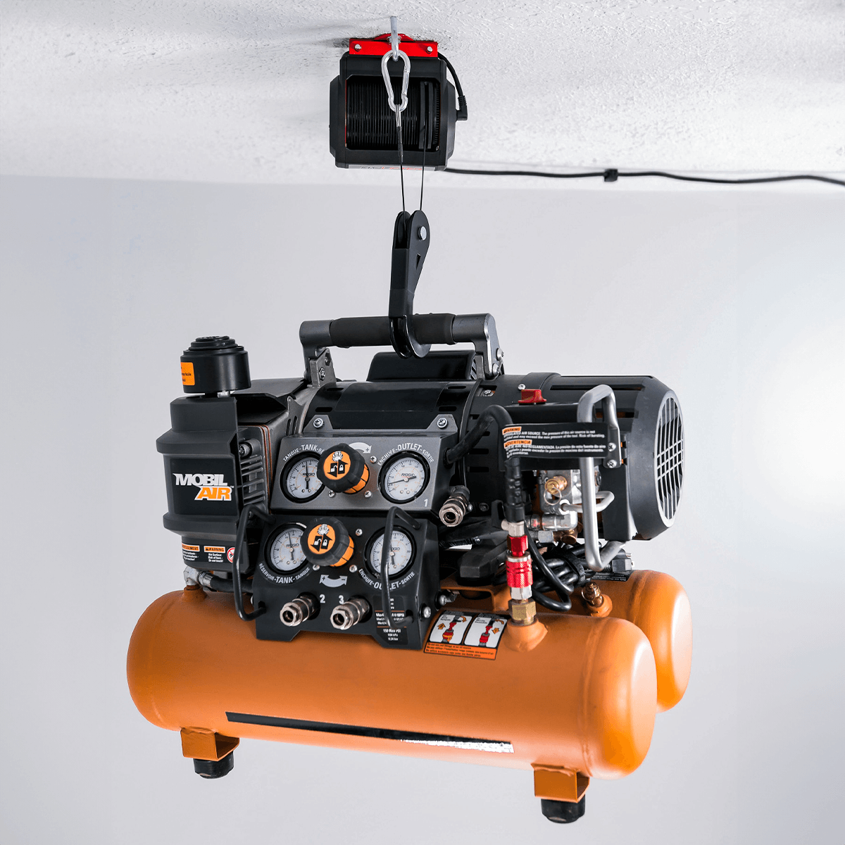 Motorized garage storage lift showcasing an overhead air compressor for efficient workspace organization.