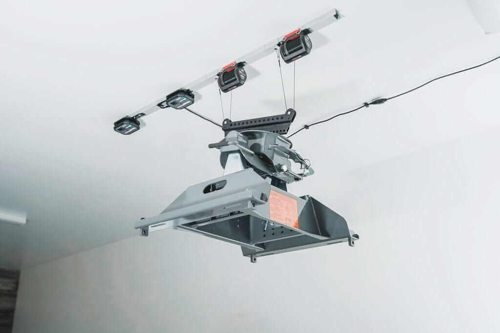 Motorized garage storage lift showcasing the Garage Smart Fifth Wheel Hitch Lifter mounted on the ceiling.