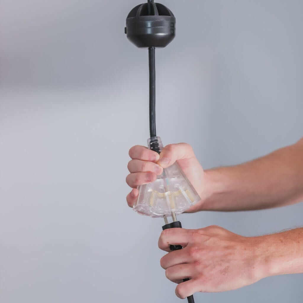 Person using the Garage Smart Power Drop cord with three outlets for motorized garage storage lift.