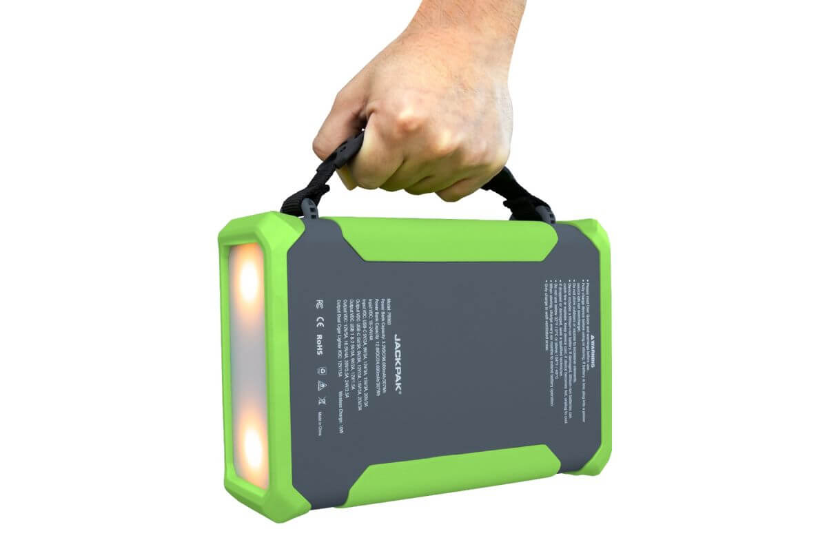 Hand holding the JackPak PB960 high-capacity power bank with bright LED lights and durable design.