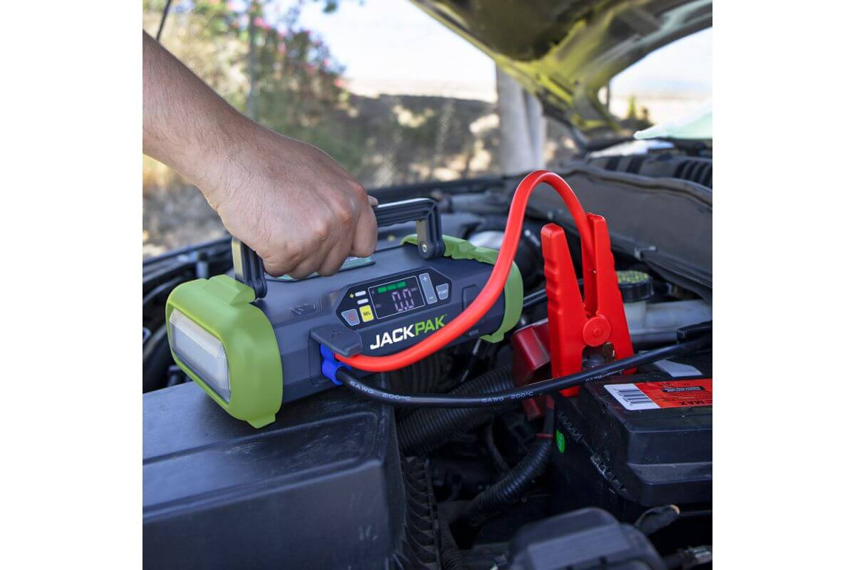 JackPak ULTRA2500A jump starter in use on a car engine with cables connected for emergency power.