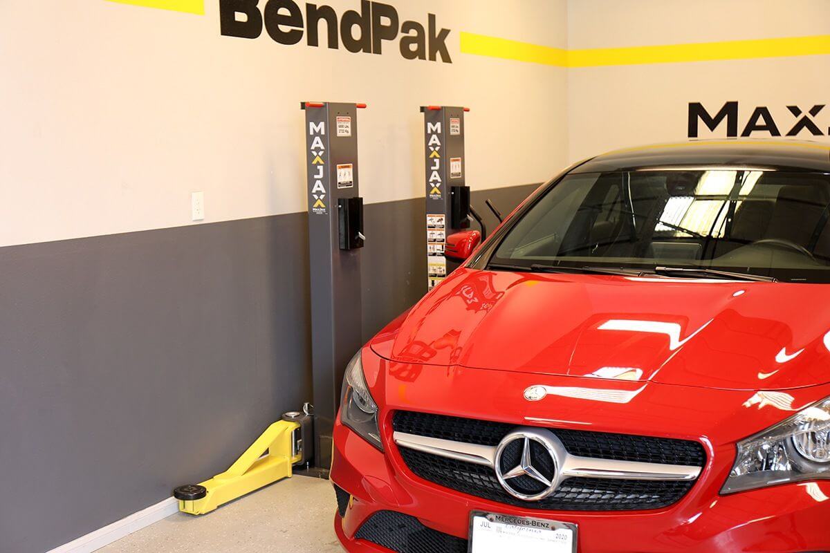 MaxJax M7K 2 Post Car Lift with a red Mercedes in a professional garage setting.