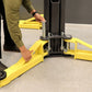 A person adjusting the safety features on the MaxJax M7K portable 2 post car lift with bright yellow arms.