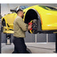 Technician using MaxJax M7K car lift for wheel maintenance on a yellow sports car.